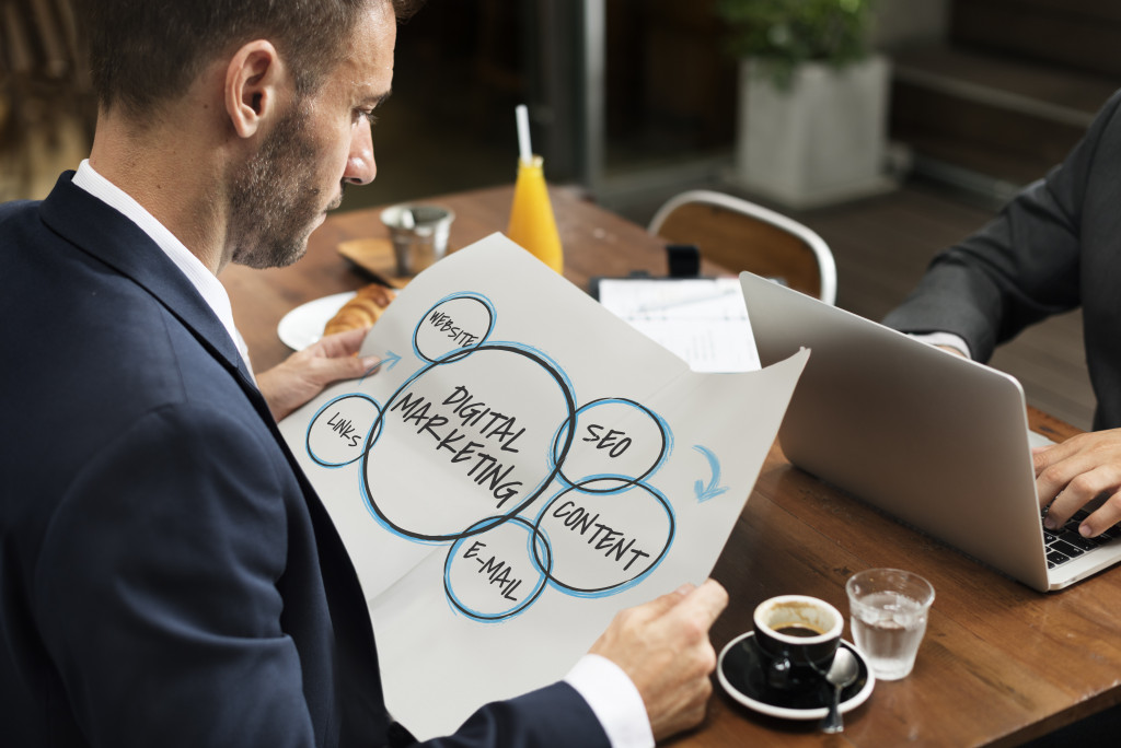 Businessman holding a drawing showing the components of digital marketing.