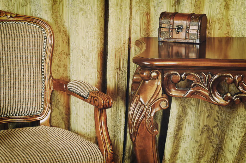 A vintage chair and table with a coffret on the table