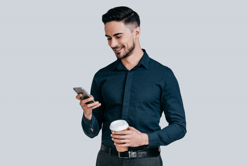 businessman checking his phone while out for a coffee