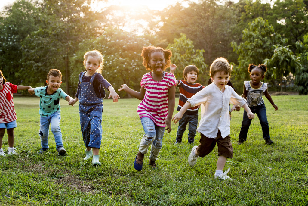 kids happily running around the field in the sunset