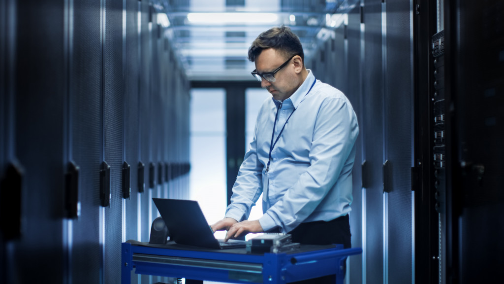 man using laptop in a data center