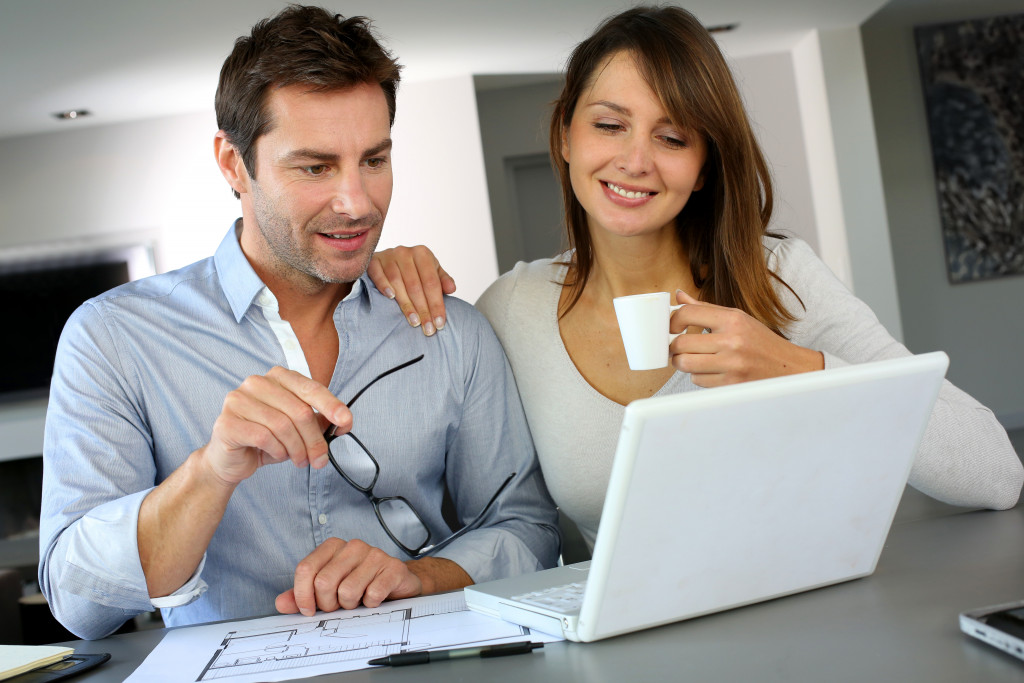 photo of couple using a laptop at home doing some research