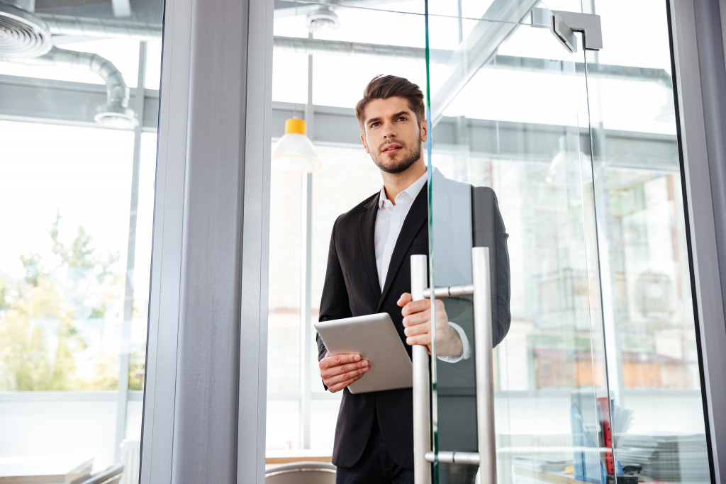 man opening door to office