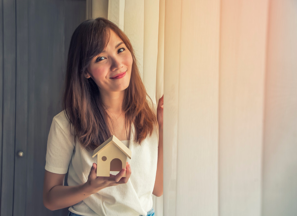 a person holding a house figurine