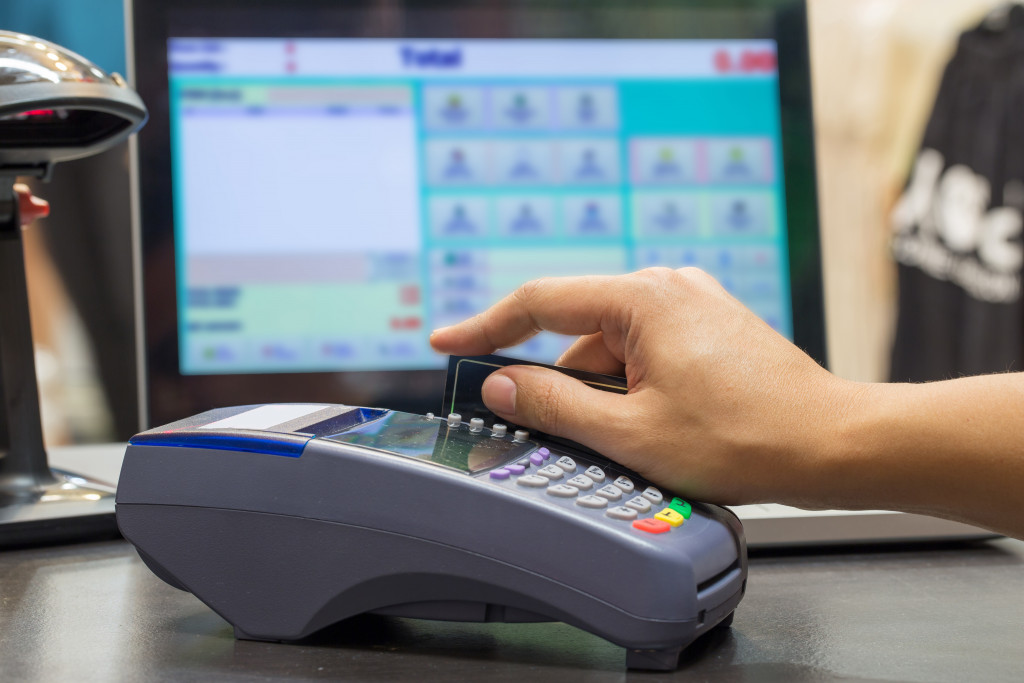 a woman swiping a card in a cashier