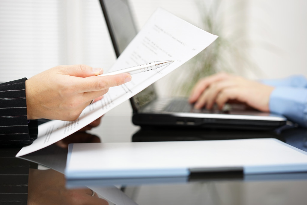 two lawyers working on a case with documents and a laptop between them