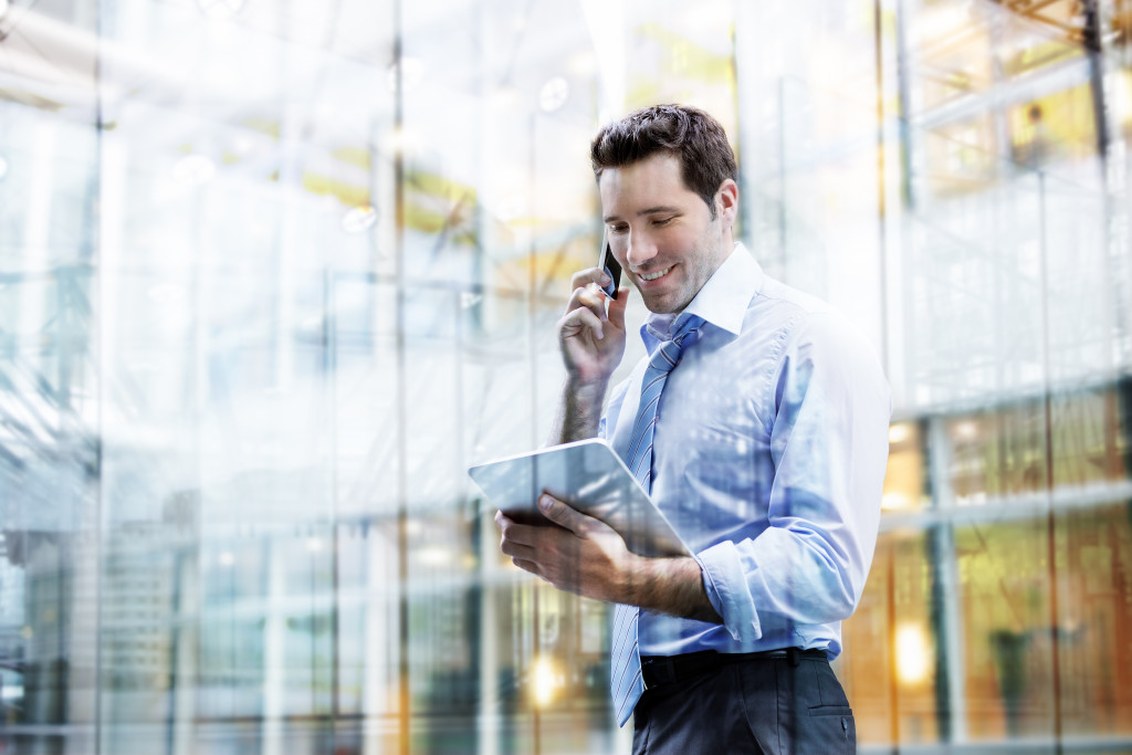 businessman using a tablet to improve his business while talking to a client