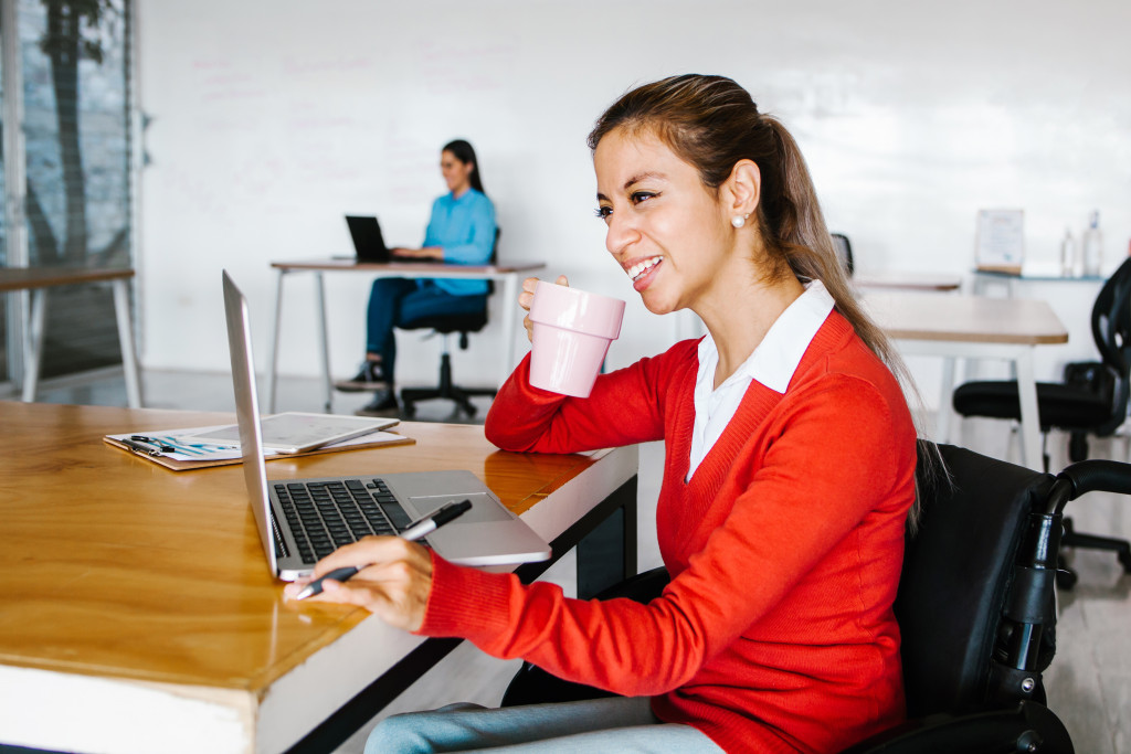 woman in wheelchair working with computer at workplace or office in Mexico city