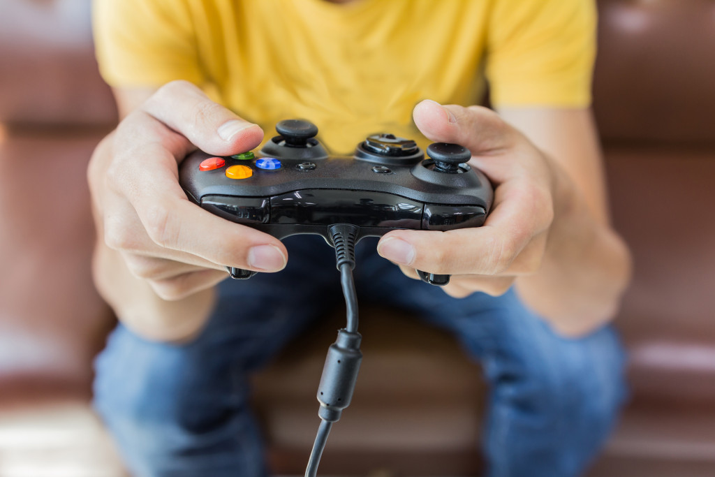 man in a yellow shirt holding an xbox controller