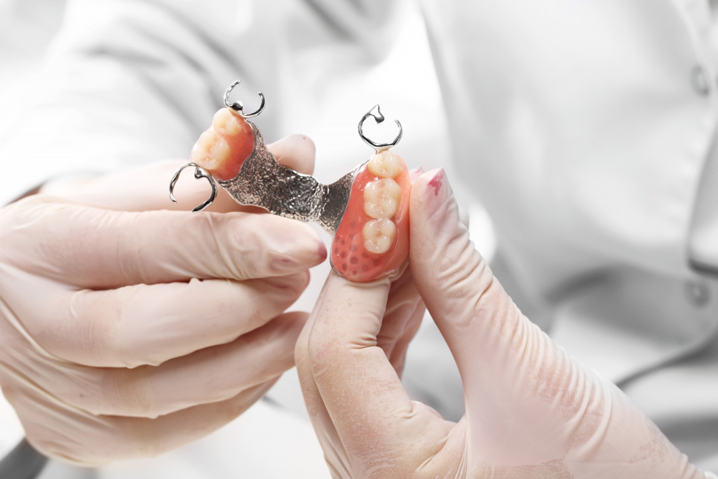 a dentist holding a denture 