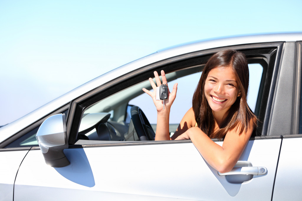 woman holding her keys while inside her car