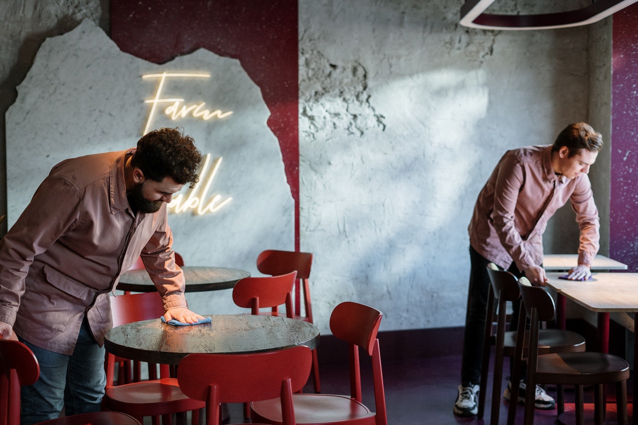 men disinfecting a table