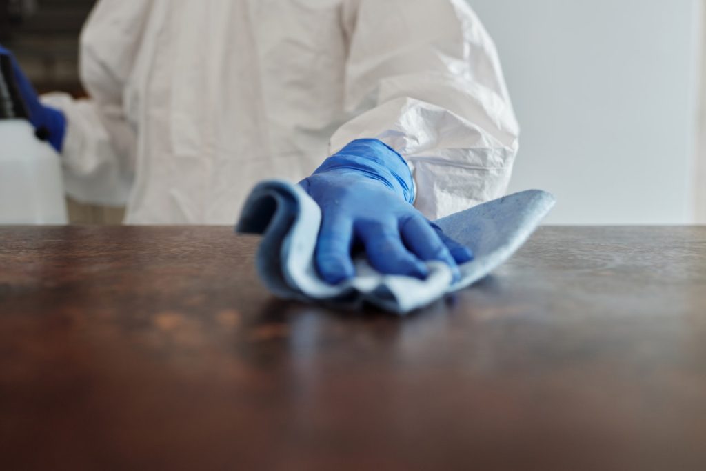 person disinfecting a surface